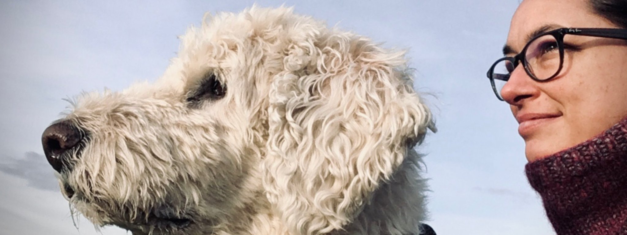 Ein helles, freundliches Porträtfoto von einer Frau und einem hellen Hund