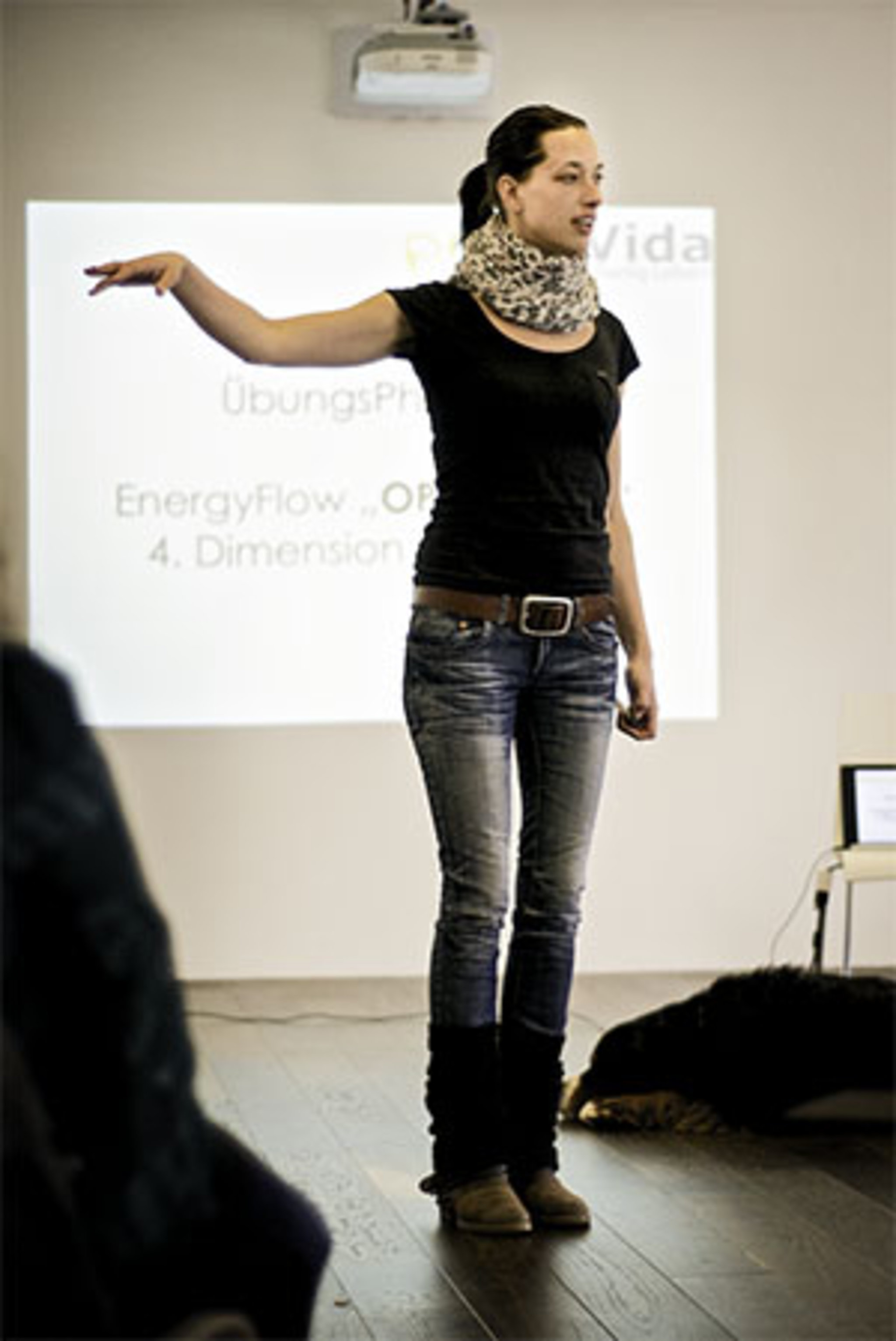 Frau hält einen Vortrag vor einer Leinwand